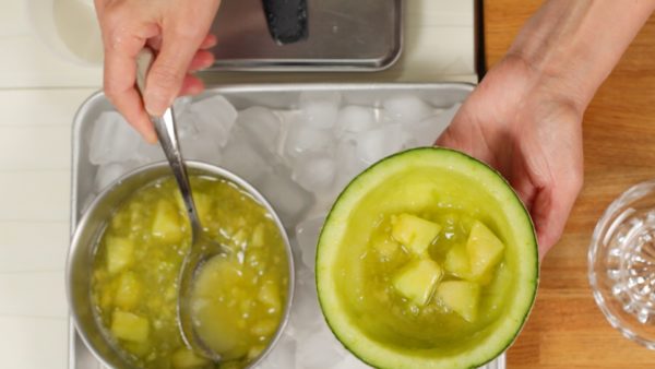 Utilizzando un cucchiaio, mettete la salsa al melone nella ciotola fatta con la buccia del melone.