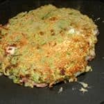 Turn the okonomiyaki over, cover and cook the other side until golden brown.
