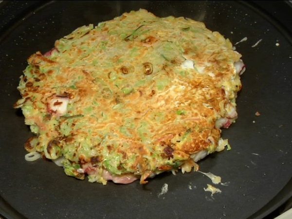 Lật bánh xèo okonomiyaki lại, đậy lại và nấu mặt còn lại đến khi nó có màu vàng nâu.
