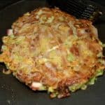 Retirez le couvercle, retournez à nouveau l'okonomiyaki et baissez à feu moyen pour cuire l'intérieur. 