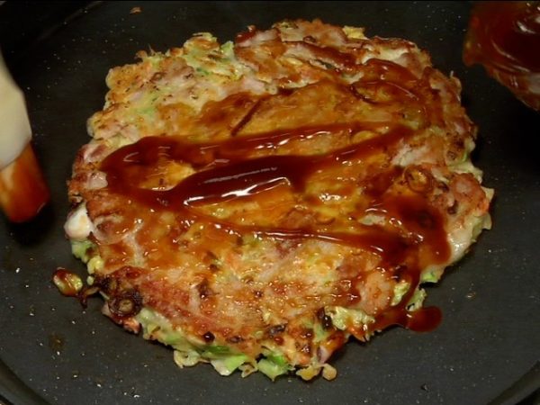 Quand c'est prêt à servir, étalez dessus de la sauce à okonomiyaki. 
