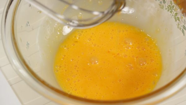 Let's make the egg mixture. Whisk one whole egg and one egg yolk in a bowl. The balloon whisk should always make contact with the bottom of the bowl to avoid creating unwanted foam.