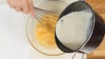 Add the cream mixture to the beaten egg a little at a time while mixing. Gradually combining the mixture will help avoid cooking the egg.