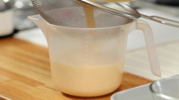 Strain the egg mixture into a pitcher. This will help the pudding to have a smooth texture. Remove the foam on the surface with a spoon.