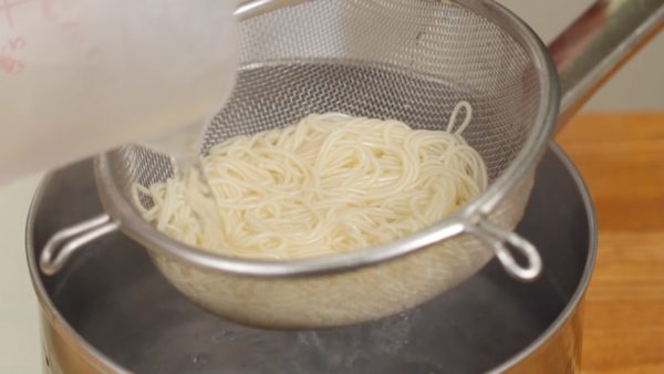 Strain the noodles with a mesh strainer. And pour water over it to reduce the temperature. Then, rinse the somen in a bowl of ice water. Make sure to remove the gooey texture on the surface.