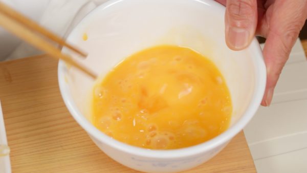 Nêm gia vị trứng bằng muối và tiêu. Đánh trứng trong bát.