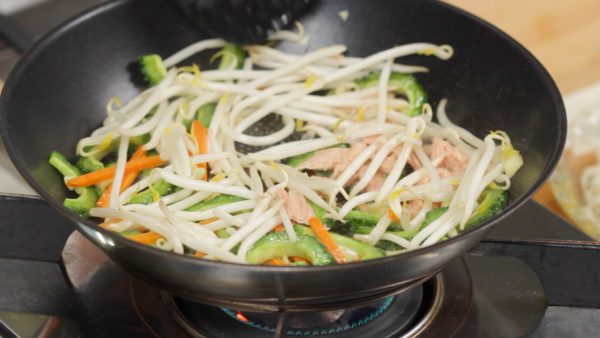 Quand les carottes se ramollissent, ajoutez le thon et les germes de soja. Continuez de faire revenir. 