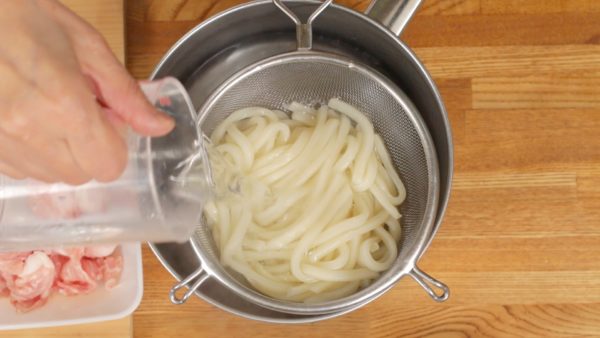 Pour water over the udon to reduce the temperature.