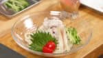 Vamos a emplatar los fideos udon de verano. Coloca las lonchas de cerdo sobre los fideos. Decora con la hoja de shiso, tomate cherry, brote de jenjibre myoga y pepino.