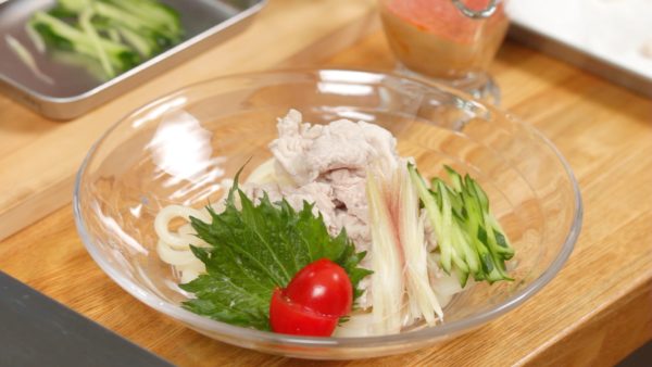 Let’s garnish the summer udon noodles. Place the pork slices on top of the noodles. Garnish with the shiso leaf, cherry tomato, myoga ginger bud and cucumber.