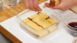 Coupez la génoise castella en tranches d'1.5cm (0.6 inch). Alignez les morceaux de castella dans le fond du plat.
