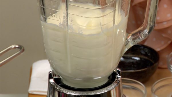 Let's make the cheesecake filling. Put the whipping cream, plain yogurt, firm tofu, cream cheese, sugar and lemon juice into a blender. Cover with a lid, pulse and then mix until smooth. A tip to blend the mixture quickly is to put the liquid ingredients first. Turn off the blender.