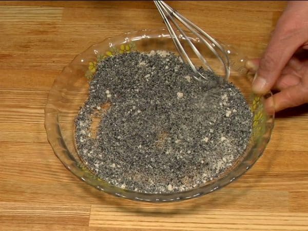 Den schwarzen Sesam fein mit einem suribachi Mörser und einem surikogi Stößel mahlen. Den Zucker hinzugeben und gut vermengen, um den schwarzen Sesamüberzug herzustellen.