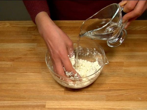 Si la pâte est sèche et friable, ajoutez un peu d'eau à la fois jusqu'à ce qu'elle devienne facile à travailler.