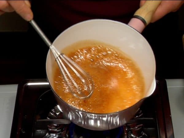 Reduzca el fuego a bajo y revuelva con una escobilla. Retire la olla del fuego y remueva la mezcla para evitar que la salsa se queme. 