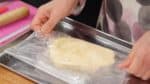 當麵團混合均勻後，把它放入一個大保鮮袋裡。用手把麵團壓平