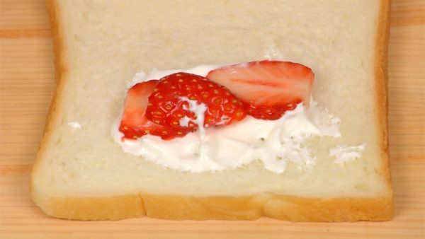 Next, we will show you how to make a rectangular sandwich. Place the strawberry slices onto the cream layer and then cover with another dollop of cream.