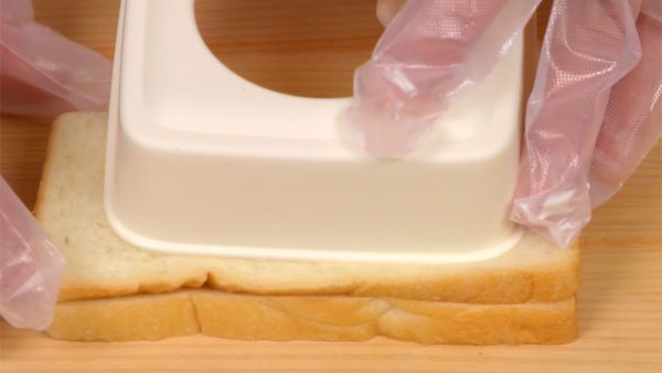 Gấp bánh mì lát thành hình chứ nhật và nhấn khuôn cắt vào nó. Nhấn và loại bỏ vỏ.
