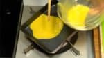 卵焼き器（またはフライパン）を中火にかけ油を薄く塗ります。適温になったら溶いた卵の半分を流し込みます。すばやく広げます。