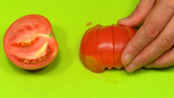 Let's cut the ingredients for toppings. Cut the tomato in half, remove the stem end and cut into 6 wedges. Chop the ham slices into thin strips.
