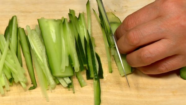 Remove the stem end of the cucumber and cut into 7cm (2.8") pieces. Slice the cucumber into thin slices and chop them into 2mm (0.08") strips.