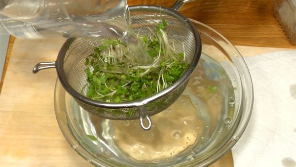 Remove the root parts of the broccoli sprouts. Rinse the sprouts in a bowl, pour some water and drain with a mesh strainer. Dry the sprouts on a paper towel.