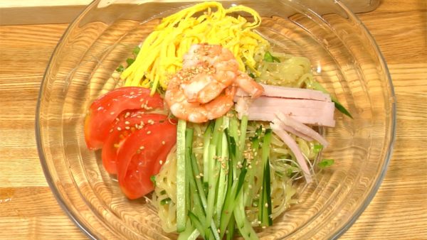 Garnish the Hiyashi Chuka with the fried egg, ham, cucumber, tomato and boiled shrimp. Finally, top with white sesame seeds.