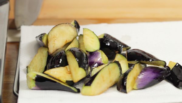 Gently press the eggplant with kitchen chopsticks to check if it is ready. When it softens, drain the oil and place the eggplant onto a paper towel.