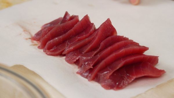 Thái cá ngừ tươi dùng làm sashimi còn được biết đến là maguro thành các lát 6~7mm (0,2 inch). Loại bỏ số nước thừa bằng khăn giấy.