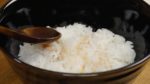 Versez la sauce sur le riz tiède. 