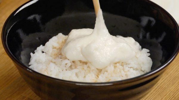 Râpez le yamaimo, igname des montagnes japonaises. C'est très gluant, n'est-ce pas ? Placez l'igname sur le riz. 