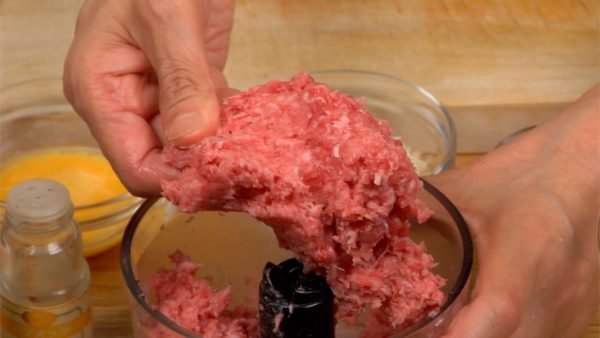 Uncover and pinch the meat to make sure it is ground smoothly. Remove the blade of the processor and place the ground meat into a bowl.