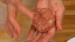 Làm phẳng hỗn hợp thịt và chia nó thành 4 phần. nặn mỗi phần thành một viên tròn và ném nó về tay bạn vài lần để loại bỏ không khí bên trong.