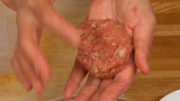 Aplatissez le mélange de viande et divisez-le en 4. Formez chaque quart en une boule et jetez-la dans votre main plusieurs fois pour retirer l'air à l'intérieur. 