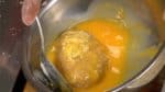 Phủi bỏ số bột thừa từ thịt ra bằng tay bạn. Nhúng miếng thịt vào trứng đã đánh và phủ kĩ nó với trứng bằng thìa.