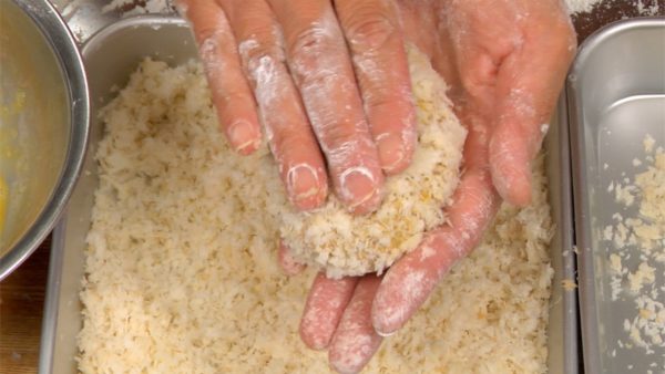 両手でパン粉と肉だねをしっかり握り、余分なパン粉を払いつつ形を整えます。