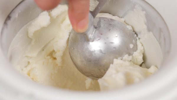 And now, the gelato is ready. Remove the cover and the mixing paddle. Take out a dessert bowl from the freezer. Dampen an ice cream scoop and make the gelato into balls.