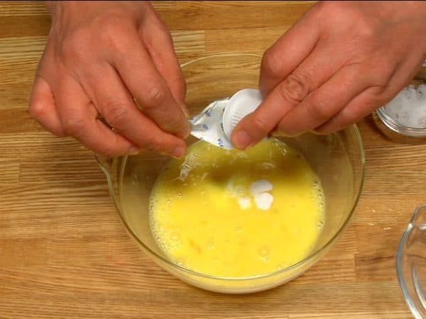 Machen wir die Ei-Mischung für das Omelette. Zwei Eier in eine Schale aufschlagen und gut verschlagen. Hier verwenden wir eine pflanzliche Milchalternative, aber wir empfehlen, stattdessen Sahne zu verwenden. Salz und Pfeffer dazugeben und die Mischung gut verrühren.