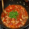 Lightly reduce the sauce and add the green peas. Continue to stir with a rice paddle.