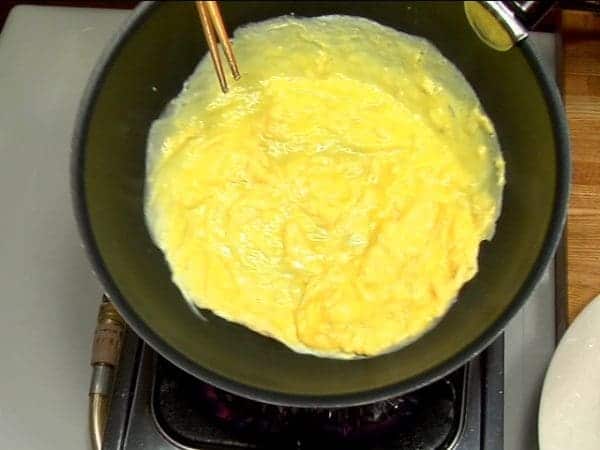 Mexa rapidamente com o hashi por 5 segundos. Espalhe  a mistura por toda a frigideira, para que todo o fundo fique coberto. Desligue o fogo. O ovo deve ficar parcialmente cozido.