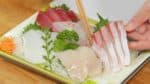 Nous utilisons un assortiment de sashimi facile à trouver mais le vrai Ryukyu dans la préfecture d'Oita utilise souvent du chinchard (aji), du maquereau (saba) ou de la sériole du Japon (buri) frais. De la gauche à la droite, nous avons de la seiche, du thon et de la sériole du Japon (buri).