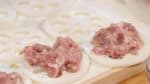 Divide the meat filling into 8 equal pieces and place each onto the slices. Press the meat into the holes.