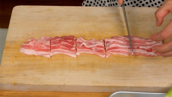 Chúng tôi sẽ cắt các nguyên liệu cho tsukemen. Cắt các lát thịt ba chỉ thành các miếng 4~5cm (1,6~2 inch). Thái hành boa rô bằng các đường cắt chéo. Ép tép tỏi và gừng bằng thìa gỗ.
