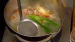 Bringt die Suppe zum Kochen und entfernt den sich bildenden Schaum mit einem Sieb. Dreht dann die Hitze zurück und lasst die Suppe für 10 Minuten köcheln.