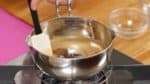 Heat a pot on low and occasionally stir the mixture. When the sugar is completely dissolved, it is ready.