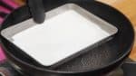 Tenez le plateau avec des pinces et faites-le flotter sur une grande casserole d'eau bouillante. Secouez doucement le plateau pour uniformiser la surface. 