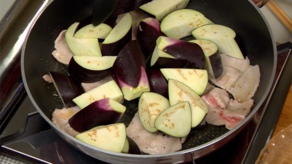 Ajoutez les morceaux d'aubergine au porc et répartissez-les rapidement avec une louche.