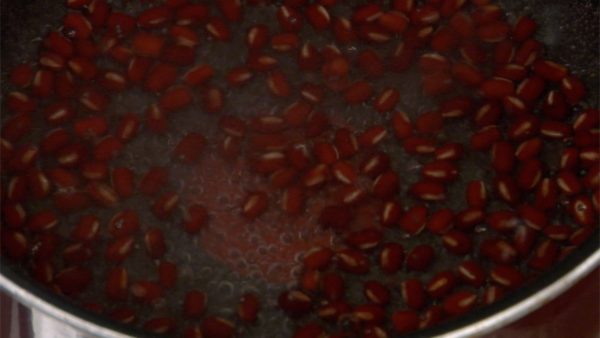 When it begins to boil, reduce the heat to low. Gently simmer the beans to avoid breaking the bean skins. Cover with a lid and cook the azuki for 25 to 30 minutes until the beans soften.