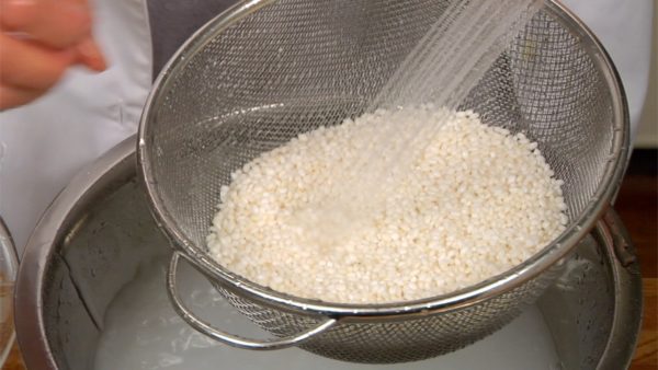 Nhẹ nhàng vo gạo dưới nước đang chảy. Cẩn thận đừng làm các hạt gạo rơi ra.