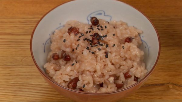 Để sekihan vào bát cơm và rắc hạt mè đen và muối để tạo vị.